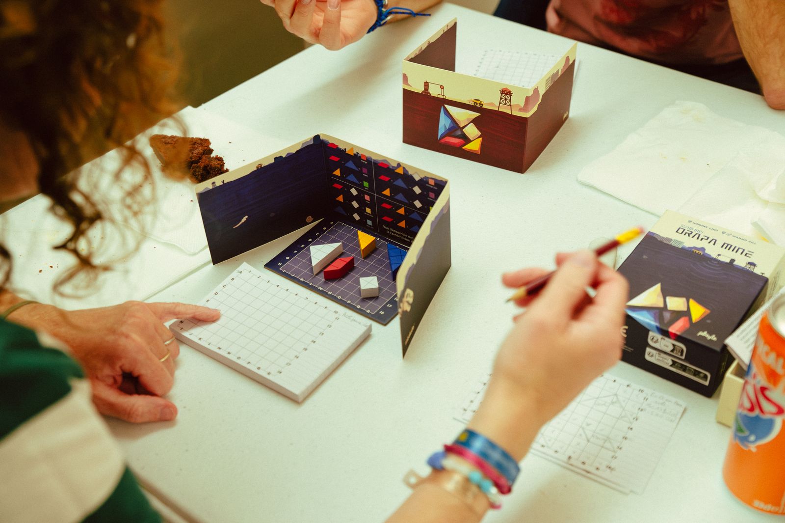 Joueurs penchés sur un jeu de société pendant une soirée mensuelle